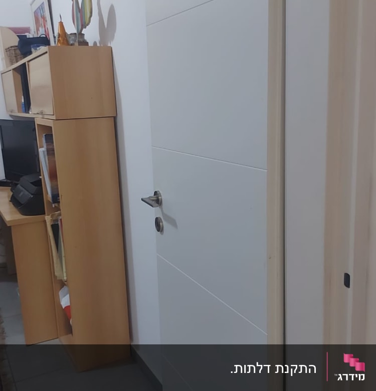 דלת לבנה עם ידית מתכת בחדר פנימי